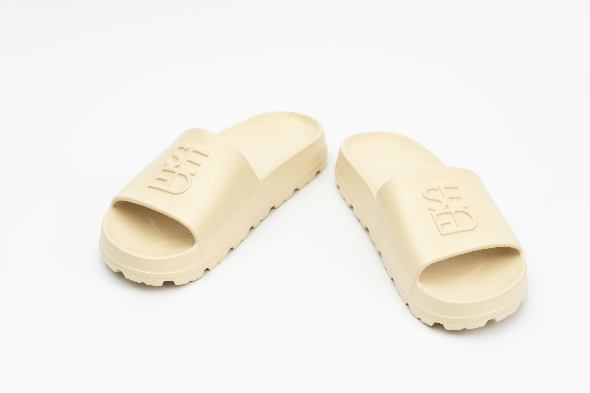 Pair of beige slides on a white background