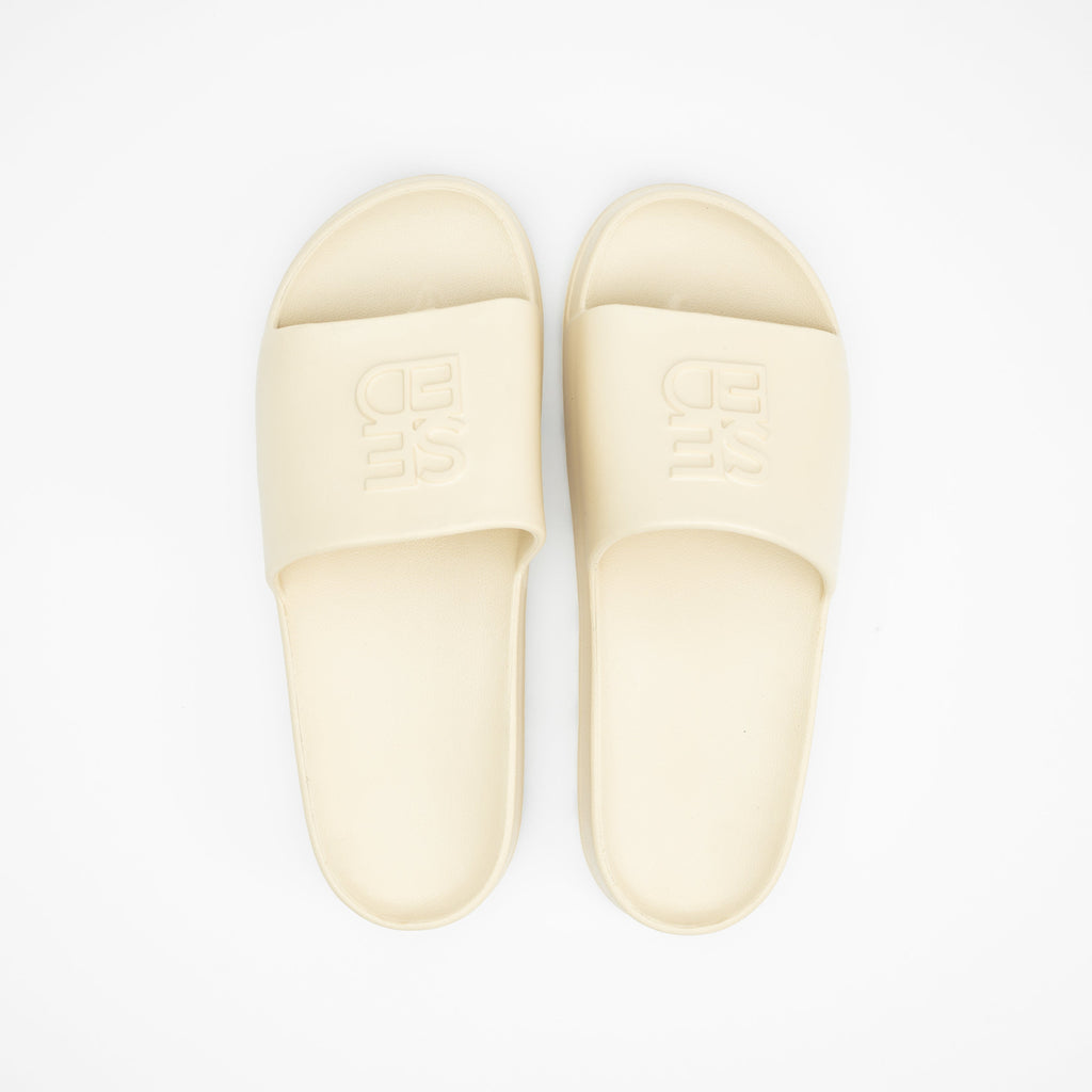 Pair of beige slippers on a white background