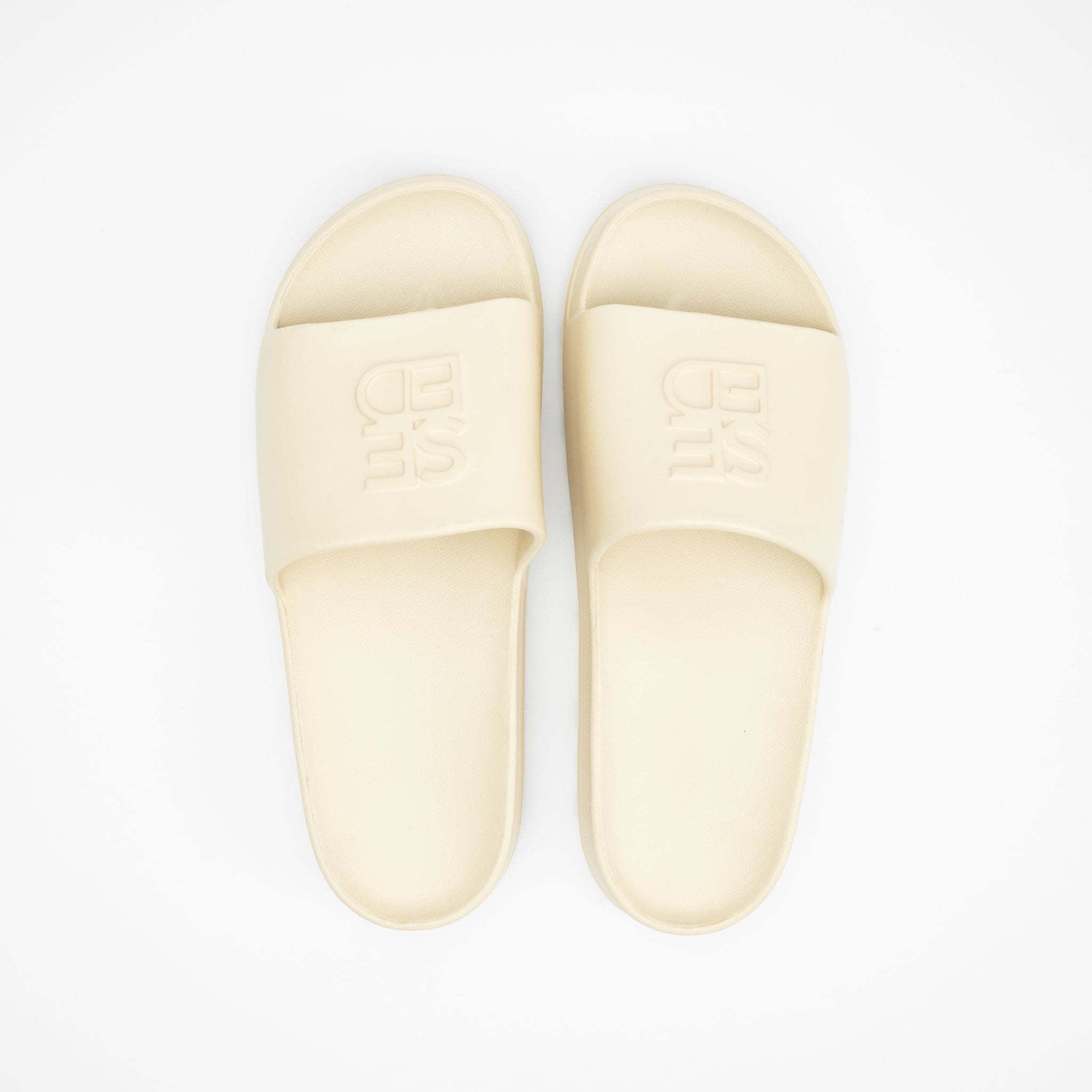 Pair of beige slippers on a white background