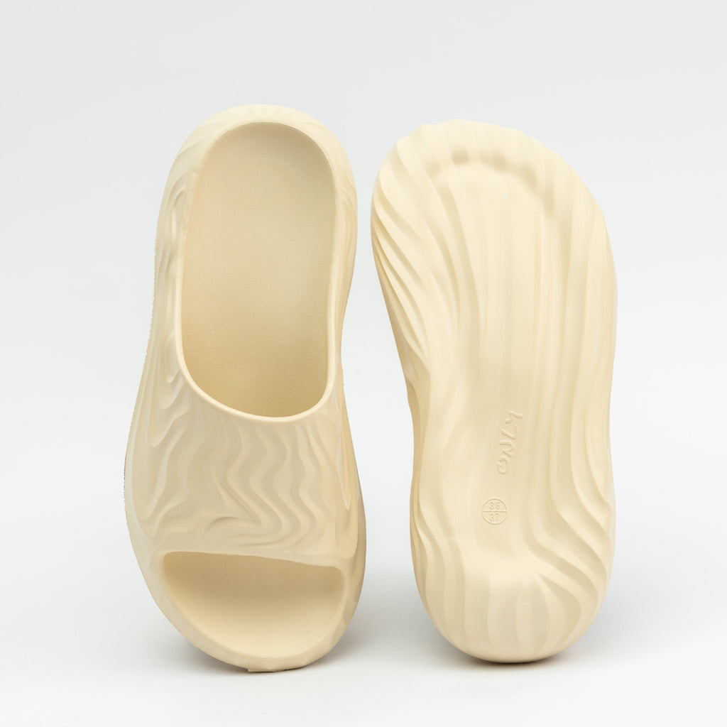 Pair of beige clogs on a light gray background