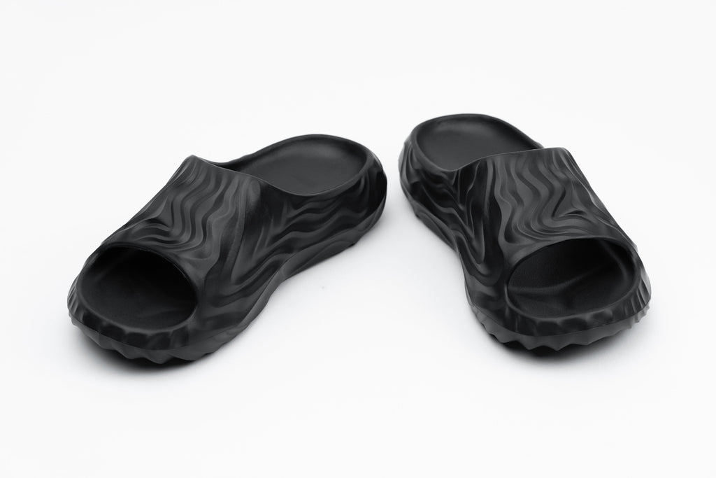 Pair of black rubber slides on a white background