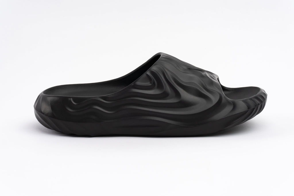 Black slipper with wavy texture on a white background