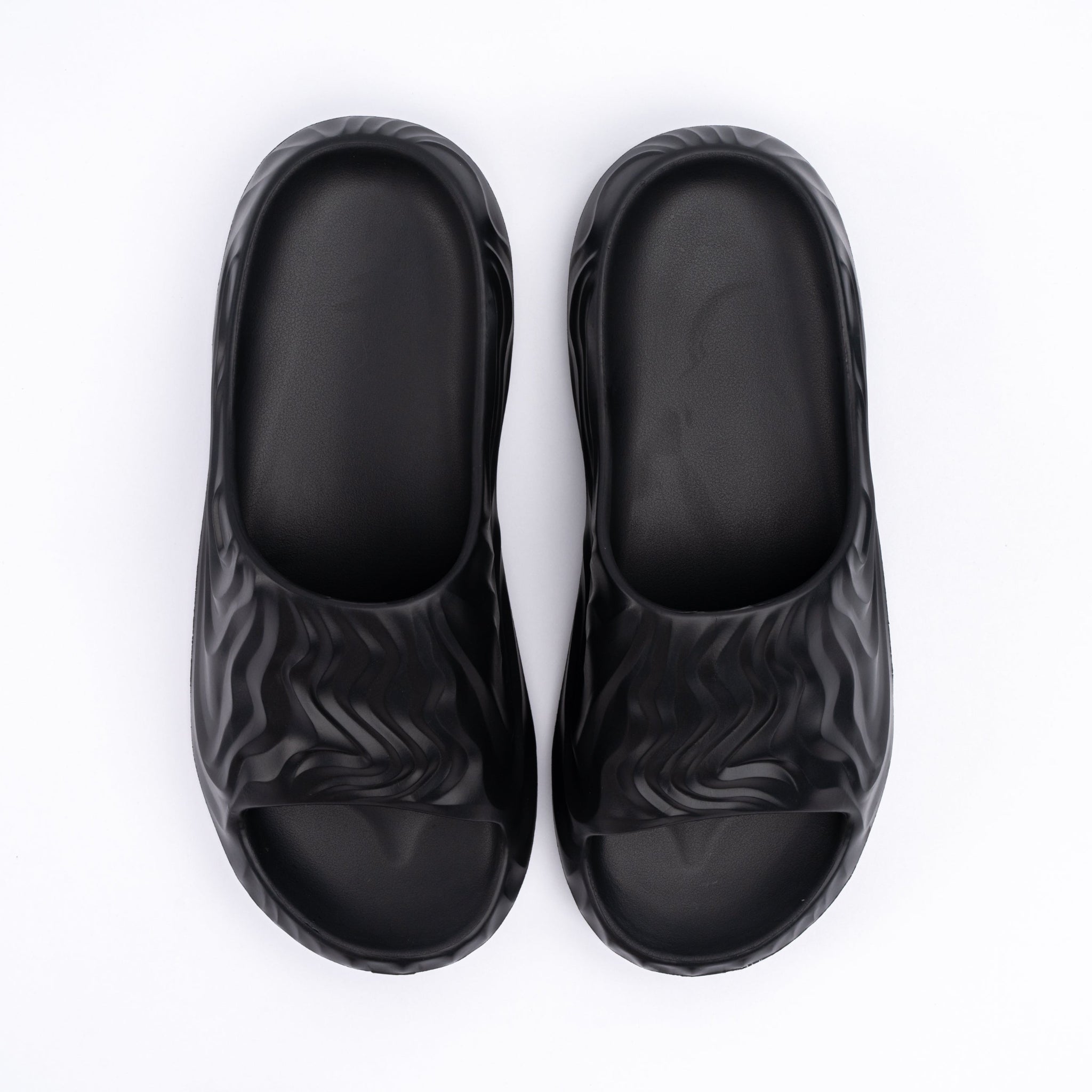 Pair of black slides with zebra pattern on a white background