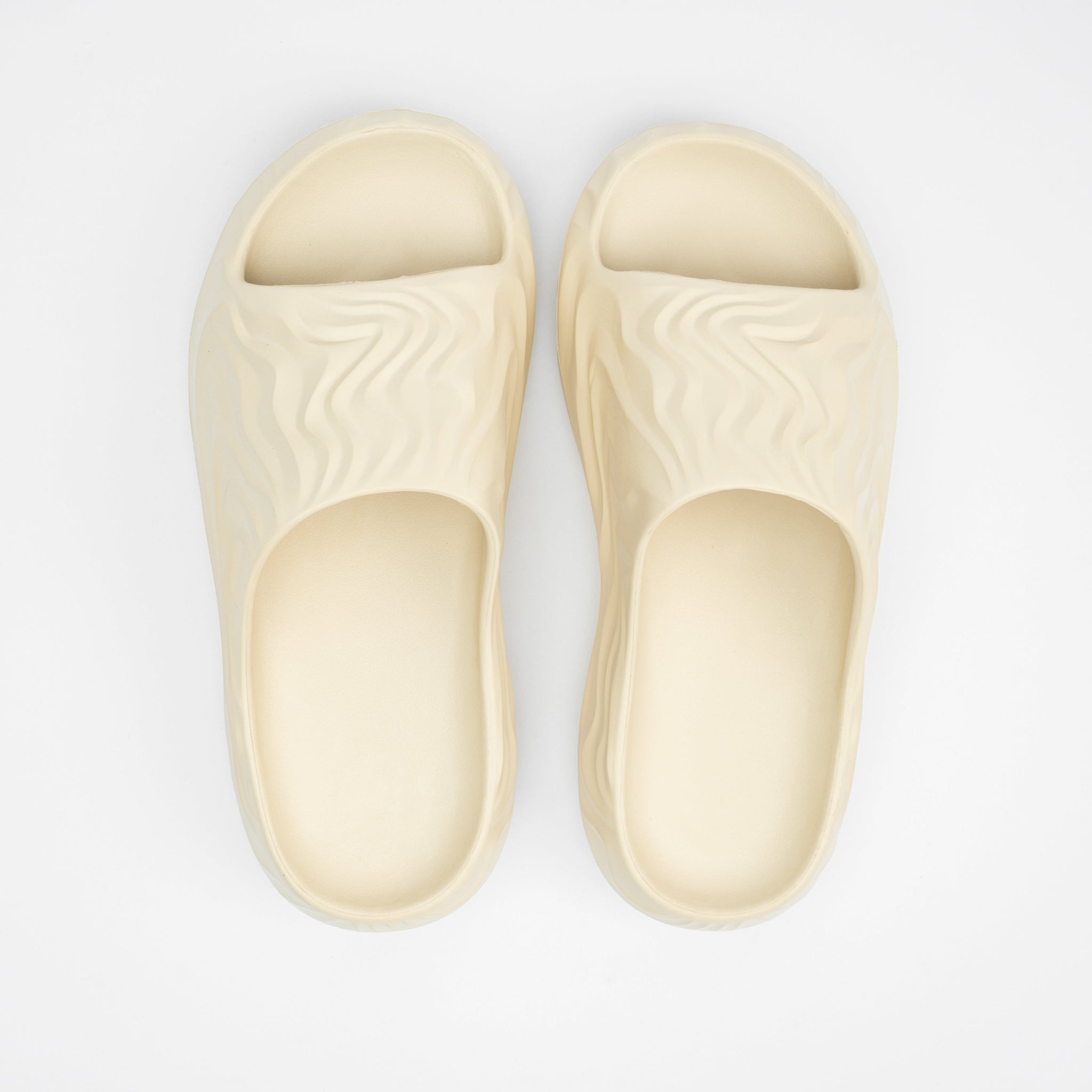 Pair of beige slippers on a light gray background