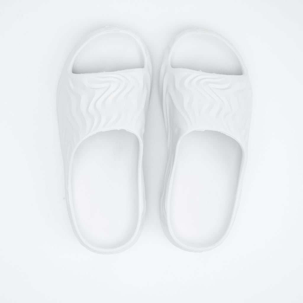 Pair of white slippers on a light gray background